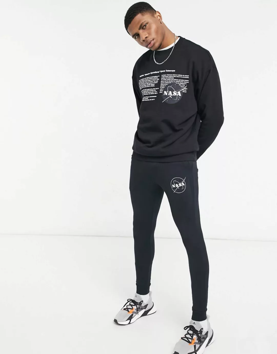 ASOS DESIGN – Supereng geschnittene Jogginghose mit NASA-Print in Schwarz, günstig online kaufen