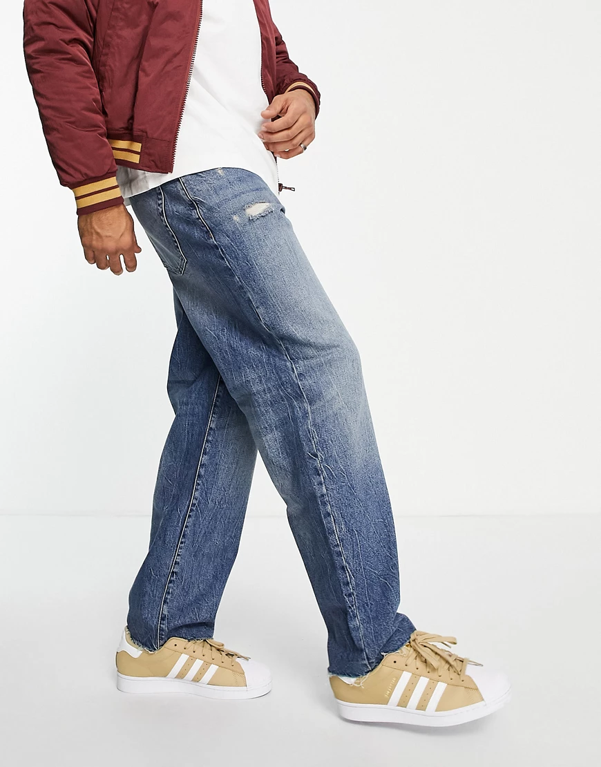 ASOS DESIGN – Baggy-Jeans in getönter, dunkler Waschung mit Abnutzungen-Bla günstig online kaufen