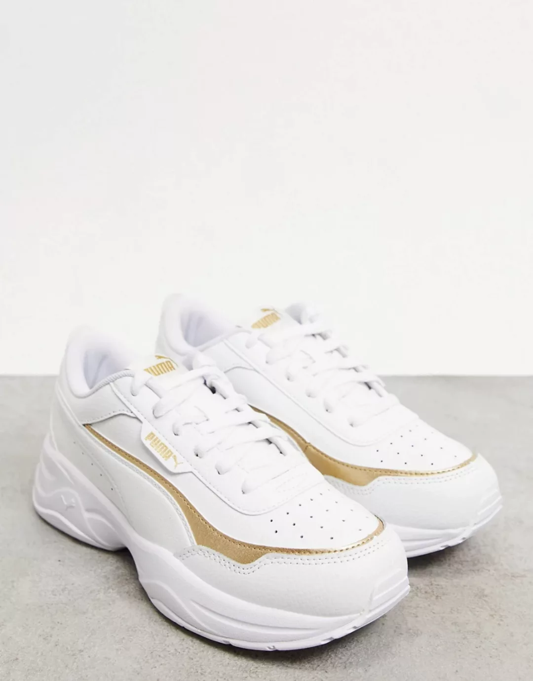 Puma – Cilia – Klobige Sneaker in Weiß und Gold günstig online kaufen