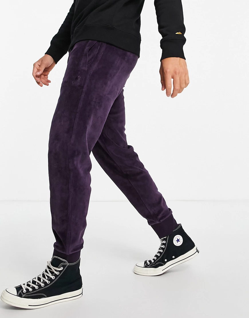 Carhartt WIP – United – Jogginghose aus Samt in Lila mit Schriftzug-Violett günstig online kaufen