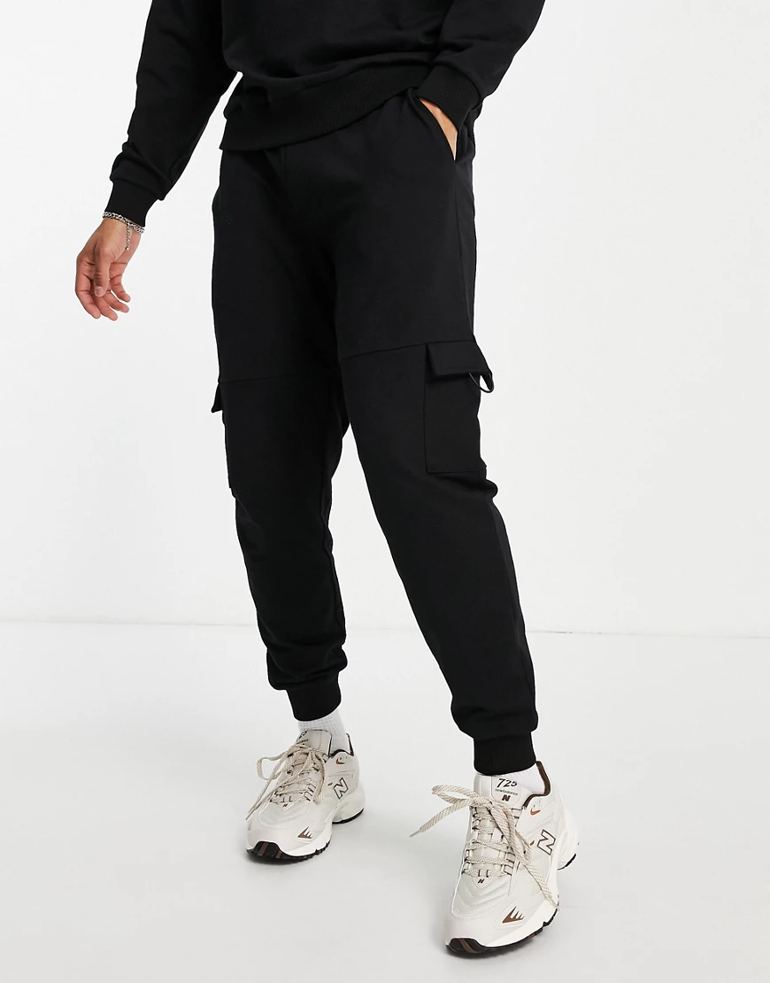 ASOS DESIGN – Schmal zulaufende Jogginghose mit Tasche in verwaschenem Schw günstig online kaufen