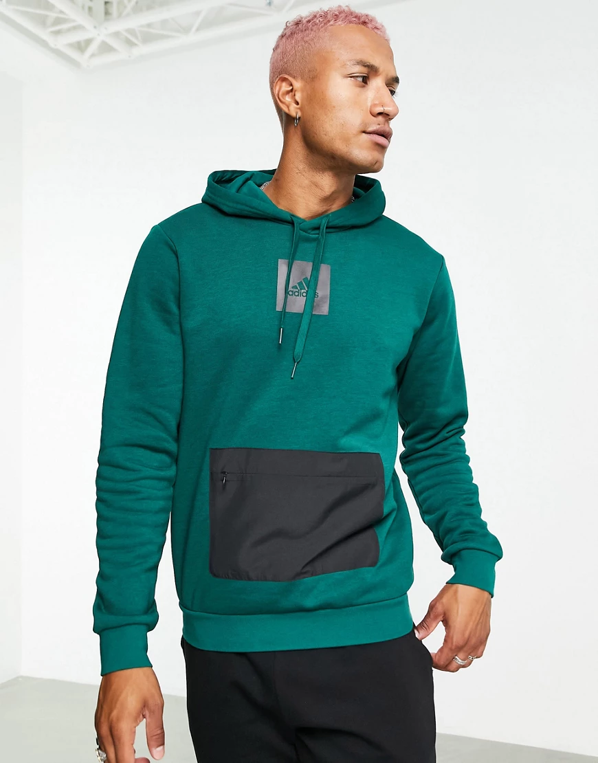 adidas – Fleece-Kapuzenpullover mit Tasche im Farbblockdesign in Dunkelgrün günstig online kaufen