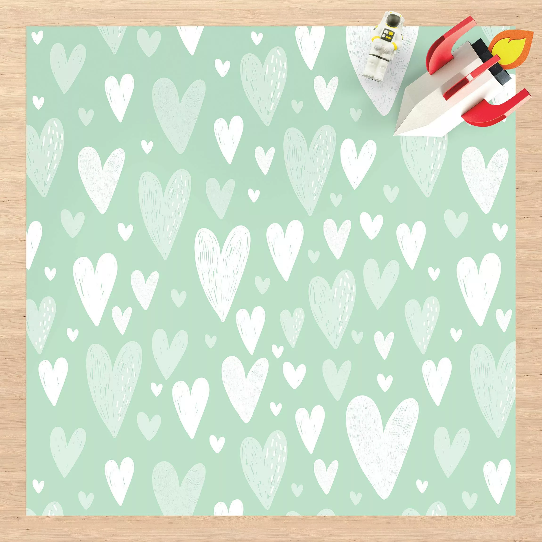 Vinyl-Teppich Kleine und große gezeichnete Weiße Herzen auf Grün günstig online kaufen