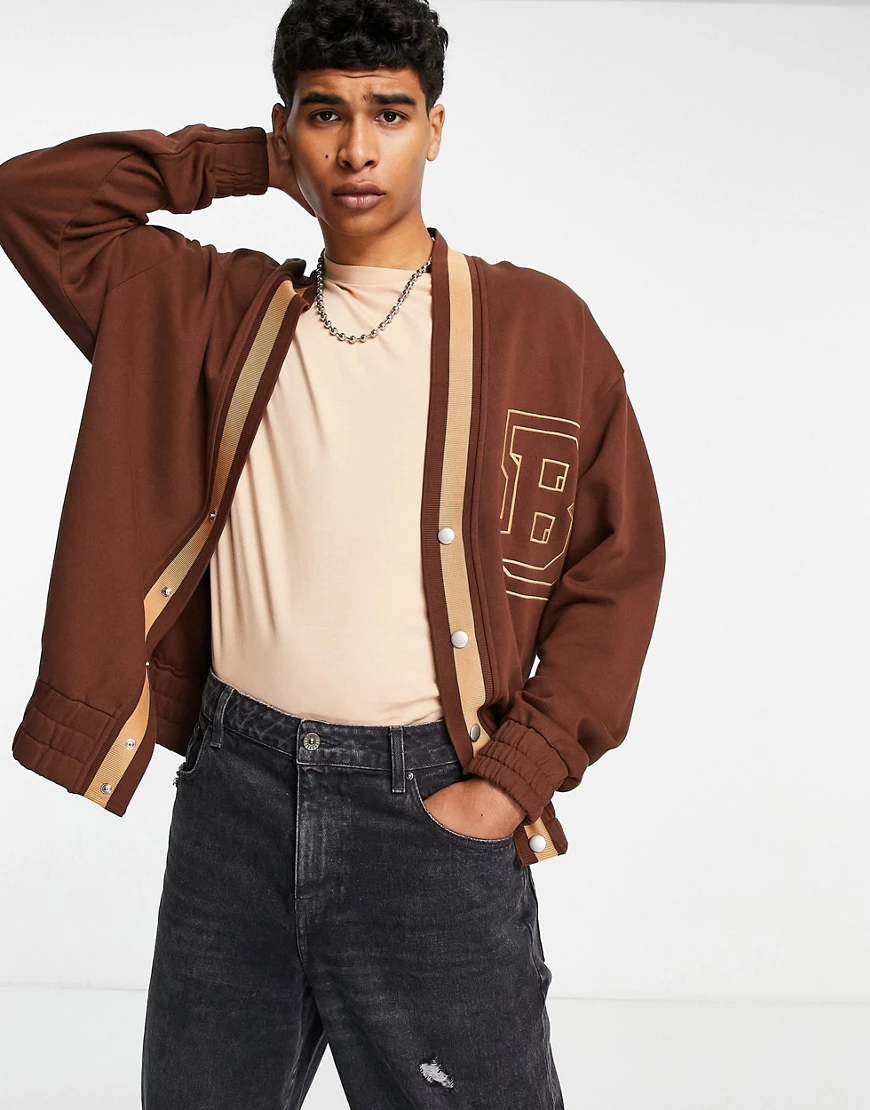 ASOS DESIGN – Oversize-Strickjacke aus Jersey in Braun mit College-Buchstab günstig online kaufen