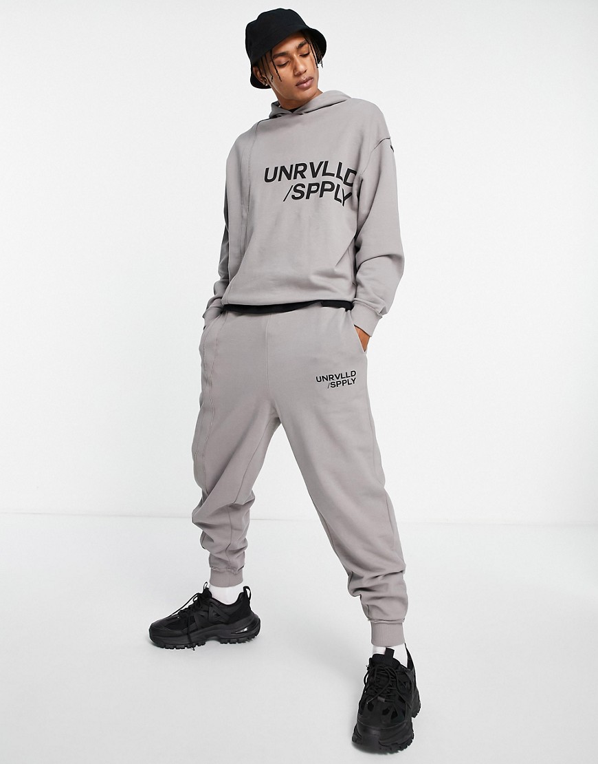 ASOS – Unrvlld Spply – Oversize-Jogginghose in Grau mit Logoprint und sicht günstig online kaufen