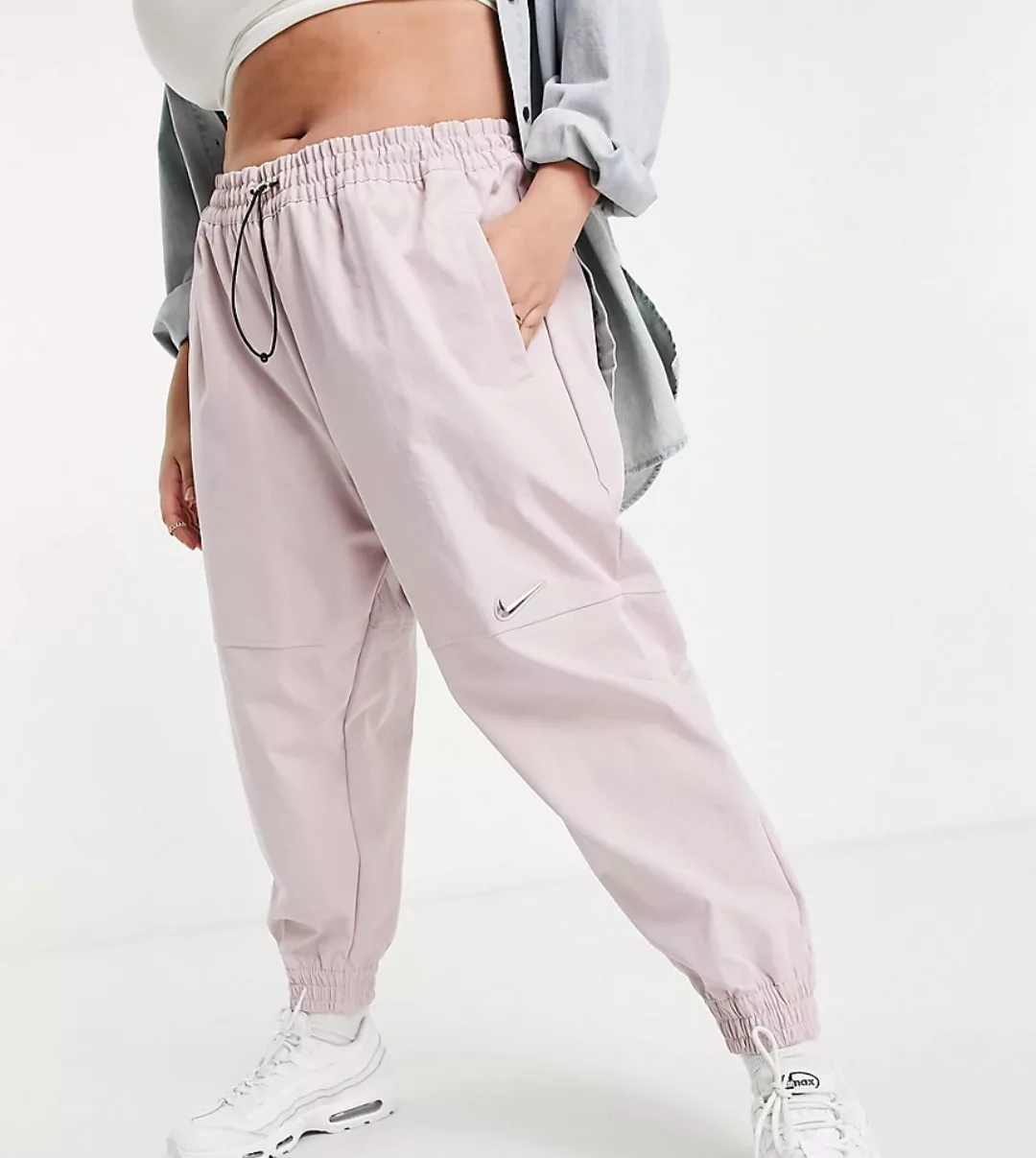 Nike Plus – Gewebte Hose mit Swoosh-Logo in Hellrosa günstig online kaufen