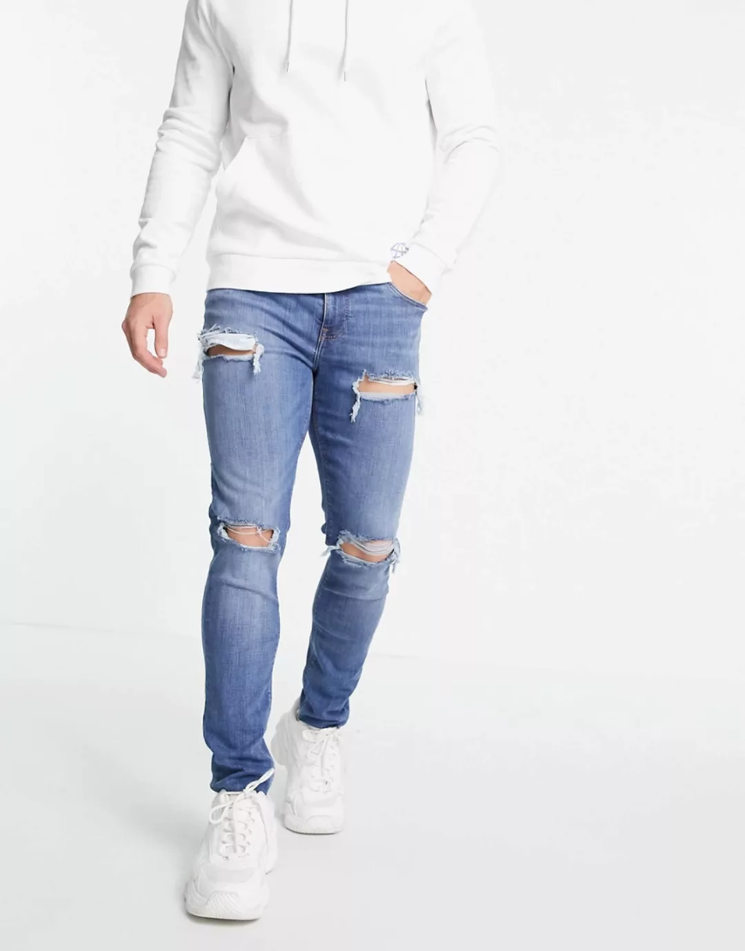 ASOS DESIGN – Enge Jeans in mittlerer Waschung mit starken Rissen-Blau günstig online kaufen