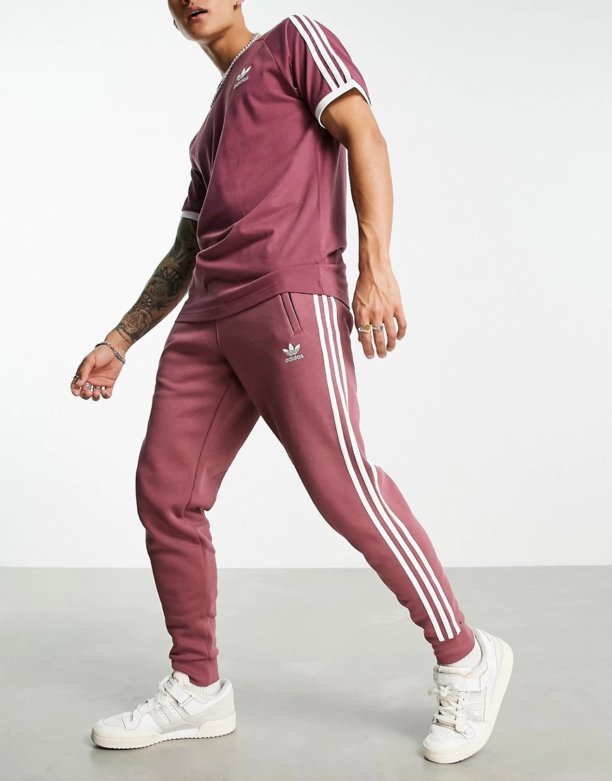 adidas Originals – adicolor – Jogginghose in dezentem Purpurrot mit den dre günstig online kaufen