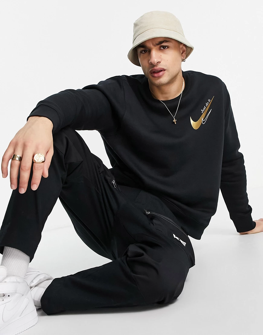 Nike – Sweatshirt in Schwarz und Gold mit Logo auf der Brust günstig online kaufen