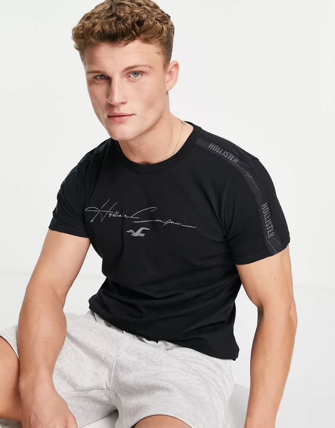 Hollister – T-Shirt in Schwarz mit Schriftzug vorne und farblich abgestimmt günstig online kaufen