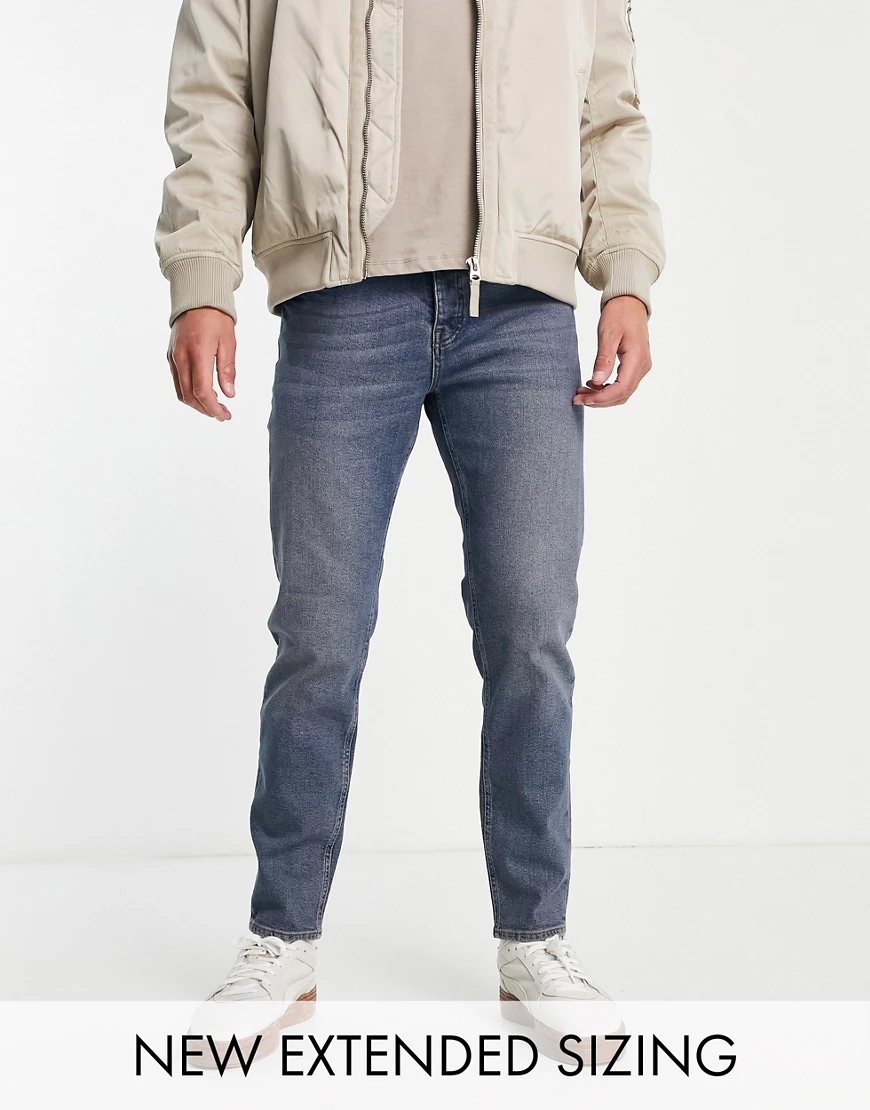 ASOS DESIGN – Schmal zulaufende Stretch-Jeans in getönter, mittlerer Waschu günstig online kaufen