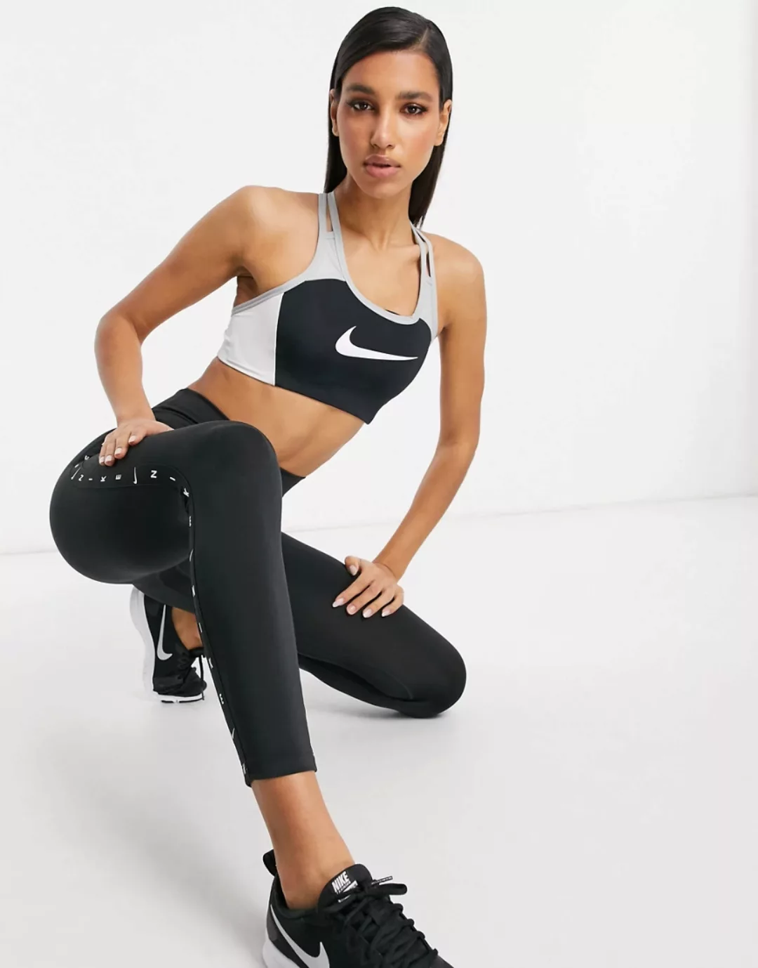 Nike – Sport-BH mit mittlerer Stützkraft und Swoosh-Logo in Schwarz/Grau günstig online kaufen