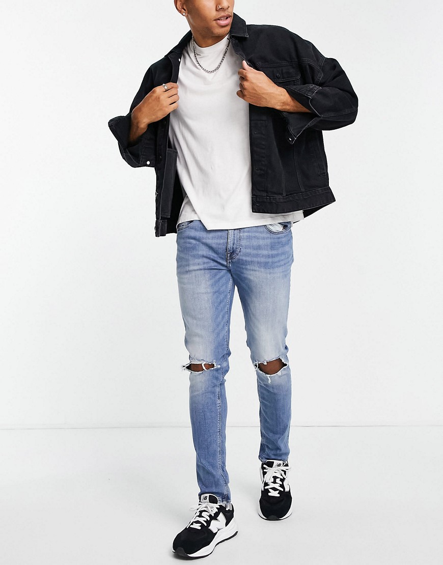 ASOS DESIGN – Enge Jeans in hellblauer Waschung mt Knierissen günstig online kaufen