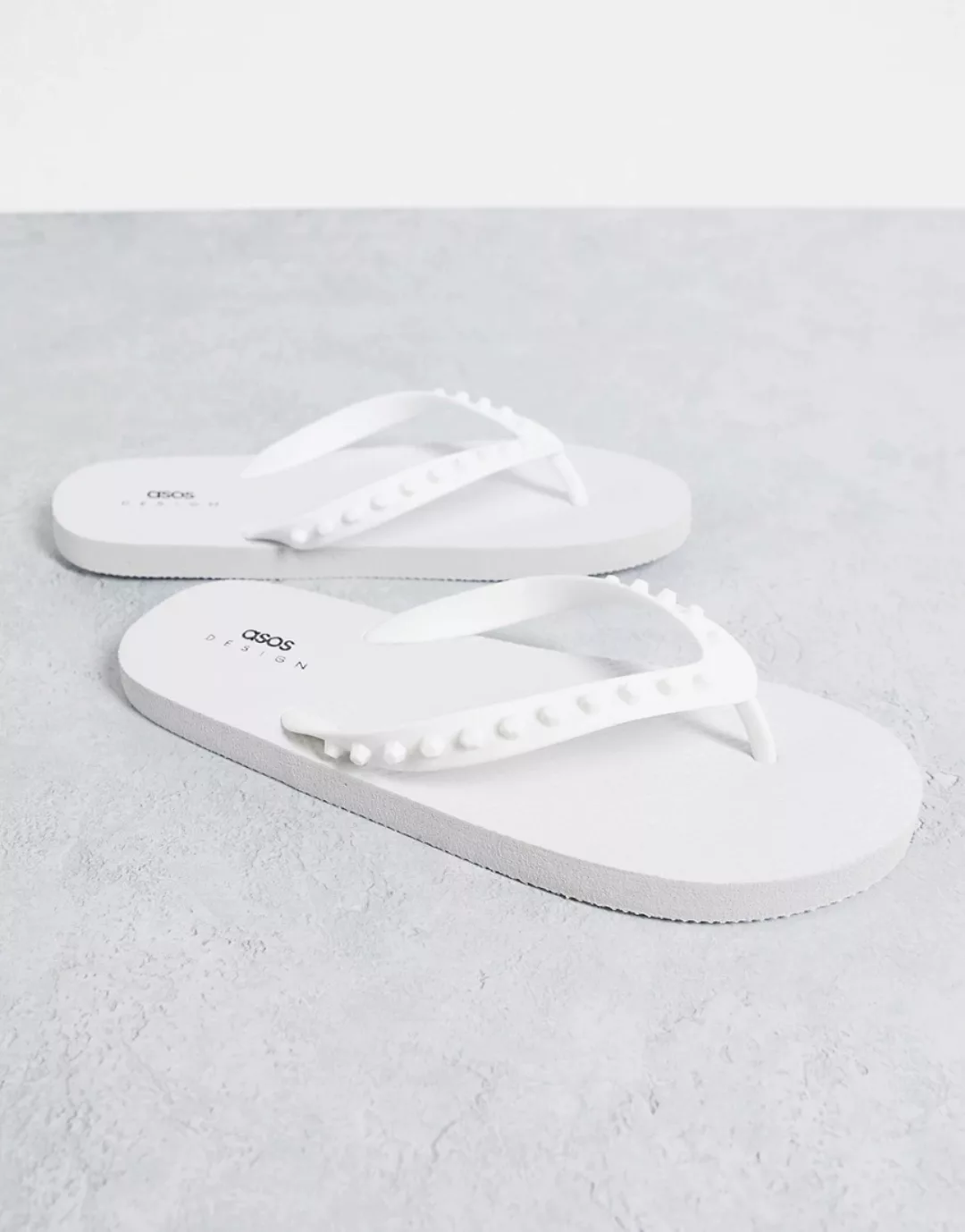 ASOS DESIGN – Zehenstegsandalen in Weiß mit Nietendetail aus Gummi günstig online kaufen