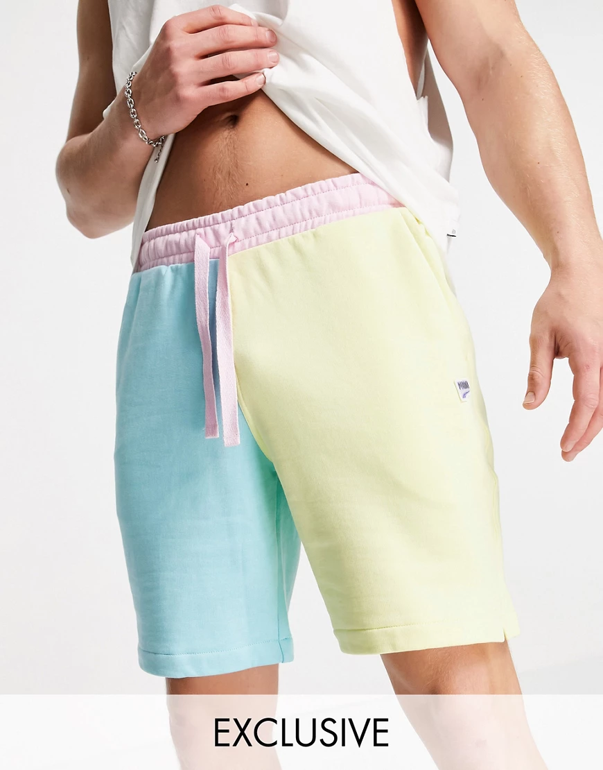 PUMA – Downtown – Asymmetrische Shorts in Grün und Rosa günstig online kaufen